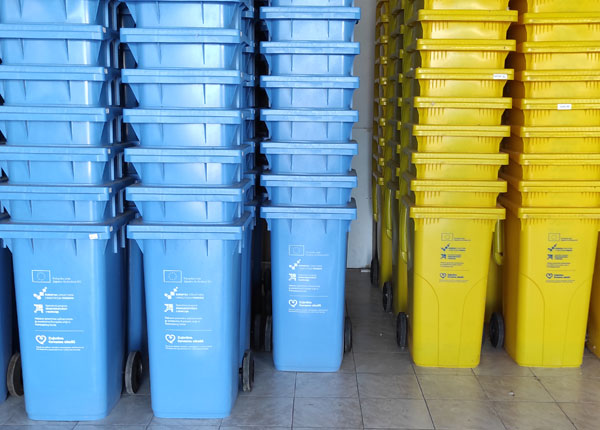 Fotografija plavih i žutih spremnika za otpad