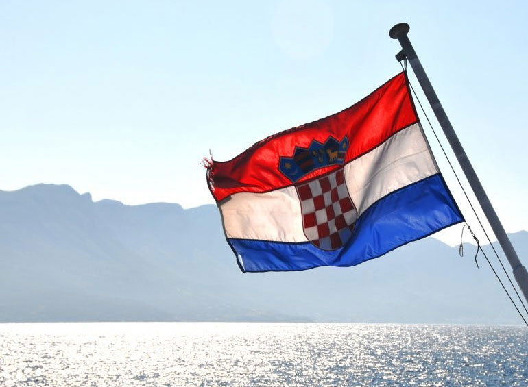Fotografija hrvatske zastave koja vijori iznad mora